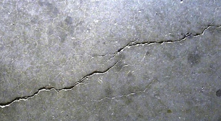 Hot cracking defect in aluminum die casting showing straight surface cracks near rib junctions